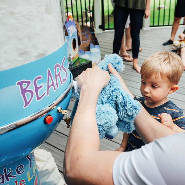 an adult helping a child make a stuffed animal